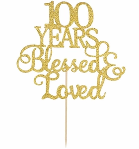 Macro detail of gold glitter cake topper featuring 100 YEARS Blessed & Loved text