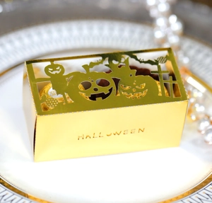 Detail of hollow pumpkin design on golden Halloween candy box with HALLOWEEN text