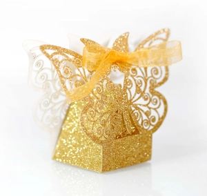 Detail of glittery gold butterfly favor box with laser-cut wings and gold ribbon bow