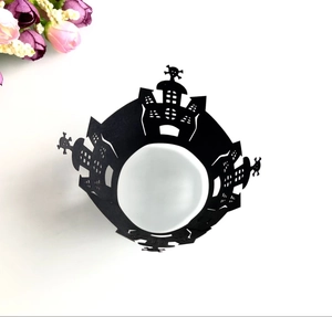 Top view of laser-cut black Halloween cupcake wrappers with castle and skull patterns