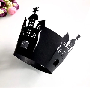 Detail showing laser-cut black Halloween cupcake wrapper with castle and skull design