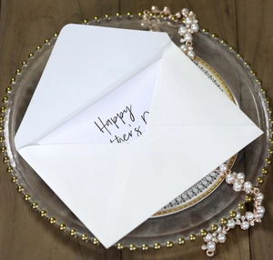 Elegant Happy Mother's Day card with white envelope on a decorative gold-rimmed plate