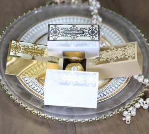 Detail of laser-cut white snowflake Christmas favor boxes with festive hollow patterns