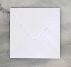 Close-up of premium white square paper envelope with flap on elegant marble surface