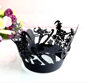 Close-up of laser-cut Halloween cupcake wrappers with witch and spider web silhouettes