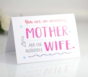 Close-up of Mother's Day card with pink and blue text on a reflective white surface