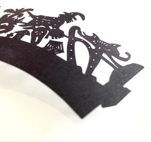 Macro view of laser-cut Halloween cupcake wrappers featuring witch and spider web motifs