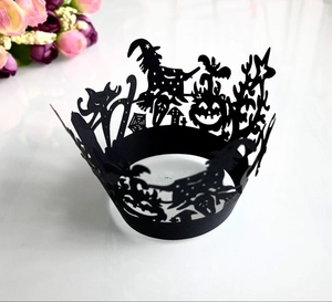 Close-up of laser-cut Halloween cupcake wrappers featuring witch and castle patterns