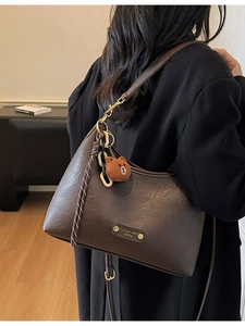 Retro dark brown leather crossbody bag with teddy bear charm and woven strap detail