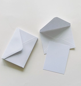 Close-up of premium white pearlescent paper envelopes and matching blank cards for invites