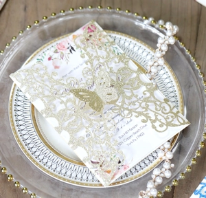 Detail showing the laser-cut golden butterfly cover and watercolor floral wedding card insert