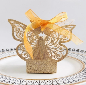 Macro detail of laser-cut butterfly candy box with gold glitter finish and silk ribbon