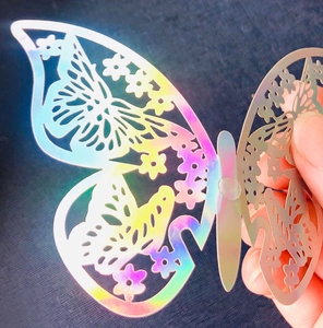 Close-up of 3D hollow butterfly wall sticker with holographic rainbow finish and floral patterns