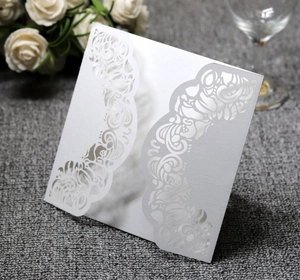 Close-up of laser-cut hollow floral patterns on white luxury wedding invitation card
