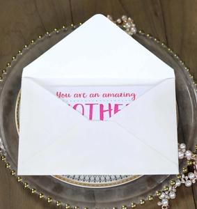 Elegant Mother's Day card with red script lettering and envelope on a glass tray