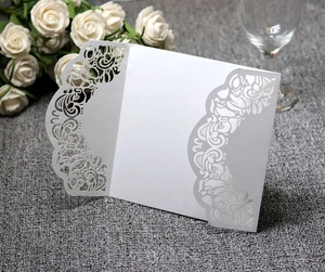 Detail of laser-cut floral pattern on elegant white wedding invitation card cover