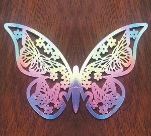 Macro shot of 3D laser silver butterfly wall sticker with hollow floral patterns