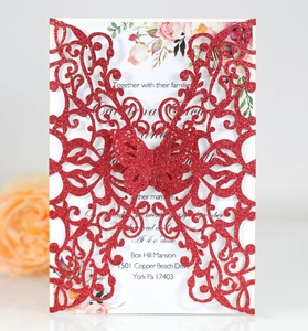 Detail of red glitter laser-cut butterfly wedding invitation with floral inner card