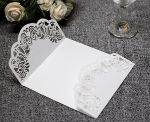 Detailed laser-cut floral pattern on elegant white wedding invitation card cover
