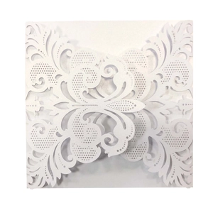 Elegant white laser-cut wedding invitation featuring intricate floral hollow patterns
