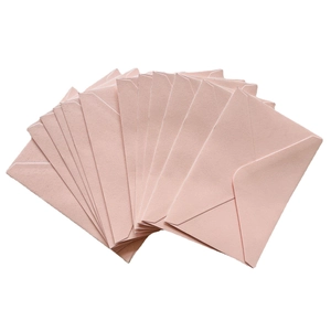 Macro fan layout of rose pink textured paper envelopes with classic triangle flap closure