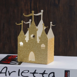 Detail der glitzernden goldenen Schloß-Bonbonschachtel mit feinen Ausschnitten für Hochzeiten
