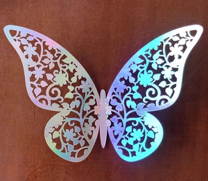 Macro shot of 3D hollow butterfly wall sticker with laser iridescent finish on wood