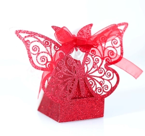 Macro detail of red glitter gift box with laser-cut butterfly and silk ribbon bow