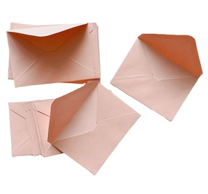 Detail view of premium light pink pearlescent paper envelopes in a stacked arrangement