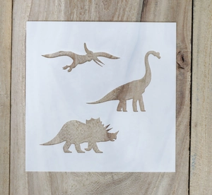 Detail showing three dinosaur shapes on white PET plastic stencil for DIY drawing art