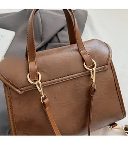Detailed macro view of high-quality gold metal hardware and brown leather stitching