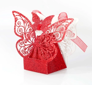 Detail of red glitter laser cut butterfly wedding favors box with a ribbon bow