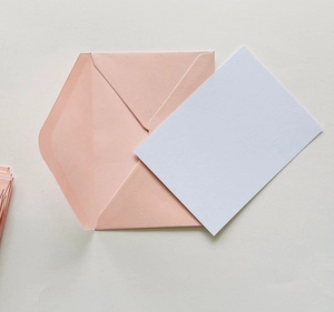 Close-up of pink western envelope and blank white card set for elegant invitations