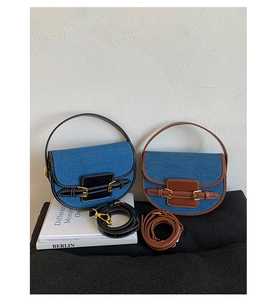 Detail of vintage denim saddle bags with contrasting leather trim and gold buckles