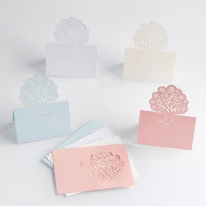 Detail of laser-cut place cards with tree and rose patterns in assorted pastel colors