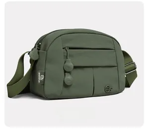 Detail view of olive green crossbody bag with multi-pocket design and nylon texture