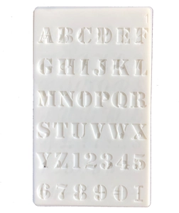 Detailed macro view of white PET stencil featuring decorative serif letters and numbers