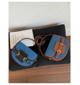 Detail of vintage saddle bags in denim and leather with dual buckle straps and stitching