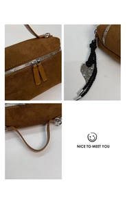 Détails du sac à main en daim marron avec pendentif cœur et fermeture éclair argentée