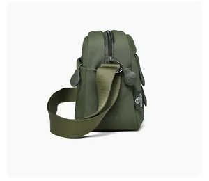 Detail view of olive green crossbody bag side structure and durable webbing strap