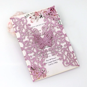 Close-up of glittery pink laser-cut butterfly invitation with floral inner card detail