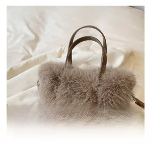 Close-up of soft plush handbag with brown leather handles and adjustable shoulder strap