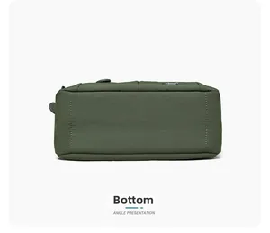Detailed bottom view of dark green crossbody bag showing stitching and durable nylon texture