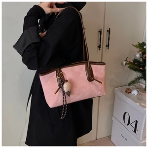 Detail of pink matte tote bag with ice cream charm and rope pendant worn by a model