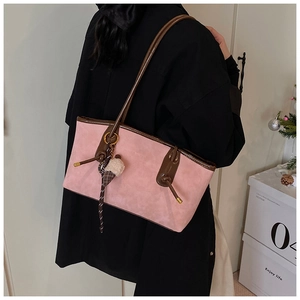 Detail of pink suede tote bag with leather straps and decorative ice cream keychain