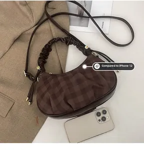 Detail of vintage brown plaid dumpling bag with ruched handle and adjustable strap