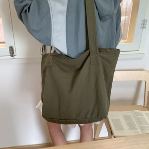 Detailed view of spacious olive green canvas tote bag showing wide shoulder strap texture