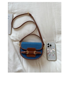 Detailed top view of retro denim saddle bag with contrast leather and buckle details