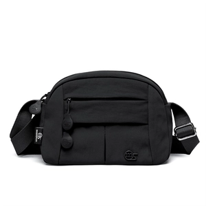Detail view of black crossbody bag showing circular logo and front zipper pocket