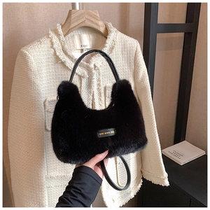 Detail of plush black faux fur handbag with love every day tag and leather handle